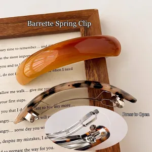 Elegant resin spring hair clips in amber and tortoiseshell patterns on vintage background