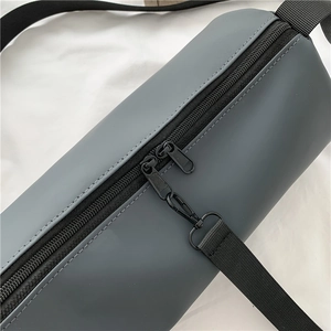 Sac cylindrique gris de sport avec fermetures noires et bandoulière en nylon réglable
