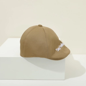 Detail of baby beret with Say Hello embroidery on khaki twill cotton fabric