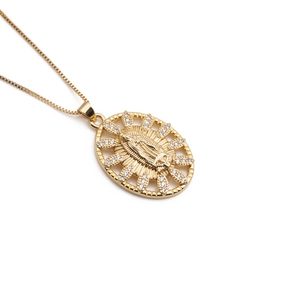 Detailed close-up of Virgin Mary gold pendant with sparkling cubic zirconia stones