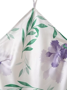 Détail d'une robe dos nu en soie avec imprimés fleurs violettes et feuilles vertes