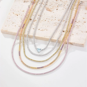 Macro detail of colorful tennis chains with heart-shaped blue zircon pendant on stone