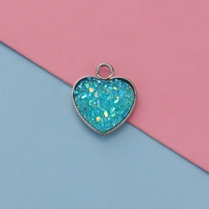 Detailed view of turquoise heart pendant with silver metal frame for jewelry making