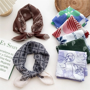 Chic cotton-linen square scarf collection with floral and plaid prints on a clean white desk