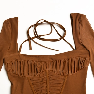 Detail eines braunen Langarmkleids mit eckigem Ausschnitt, Raffungen und Schnürung