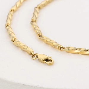 Detailed macro view of the gold Mobius twist stainless steel chain and spring clasp