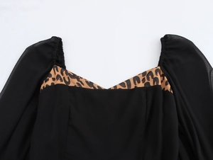 Détail du col léopard élégant et des manches bouffantes noires sur la robe longue