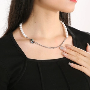 Detail of butterfly pearl and chain necklace worn on model for a trendy look