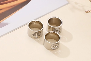 Detailed view of polished silver titanium steel rings with tree of life cutout patterns