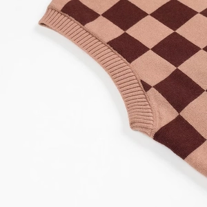 Gros plan détaillé du tissu en maille à damier marron et beige avec bordure côtelée