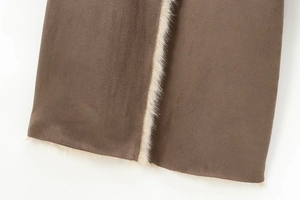 Detailed close-up of brown faux suede fabric with thick white sherpa wool lining