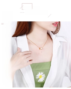 Detailopname van een goudkleurige cilinderketting met wit keramiek bij een model