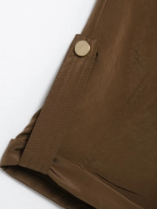 Détail de la chemise utilitaire marron avec double couture et bouton en métal doré