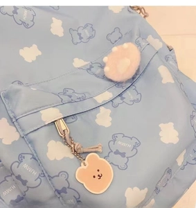 Close-up of light blue backpack with bear prints and a cute bear silicone pendant