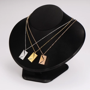 Three magnetic envelope pendant necklaces in silver, gold, and rose gold on a neck bust