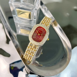 Detailed view of women's gold quartz watch with oval red dial and crystal-encrusted band