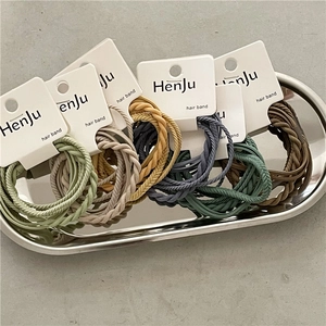 Five-pack of braided elastic hair bands in Morandi colors on a silver metal tray