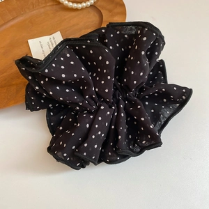 Macro shot of polka dot chiffon fabric detail on a large ruffled hair scrunchie