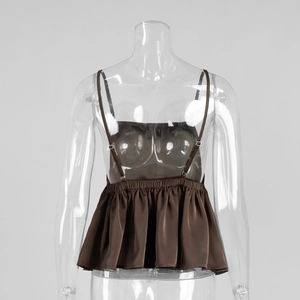 Detail of dark brown satin camisole featuring adjustable spaghetti straps and ruffled hem