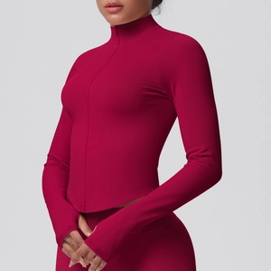Detail view of burgundy yoga jacket with stand collar and functional thumbhole cuffs