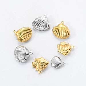Macro view of gold and silver stainless steel ocean shell and fish charms for DIY jewelry