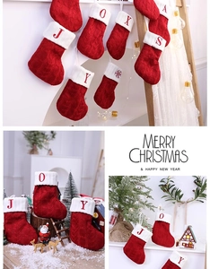 Detail of red and white knitted Christmas stockings with festive embroidered letters