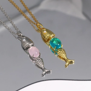 Detail view of fish pendants with pink and blue gemstones and small white pearls