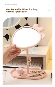 Close-up of pink bow vanity mirror with a 360-degree rotating oval glass and storage base