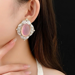 Vintage gold earrings with pink oval gemstone and white enamel frame in luxury style