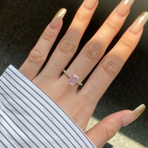 Close-up of a pink radiant cut zircon ring with side stones on a woman hand