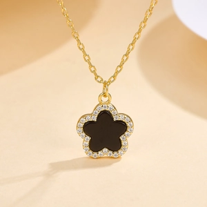 Dettaglio macro della collana in argento 925 placcato oro con stella nera e pietre lucide