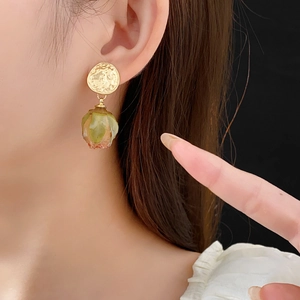 Close-up of vintage rose petal earrings with gold round studs on a female model