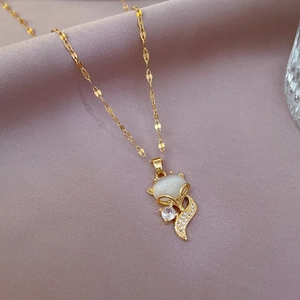 Macro shot of gold fox pendant with white cat eye stone and cubic zirconia inlay