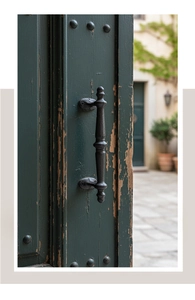 Close-up of vintage industrial cast iron door handle on a rustic green wood door