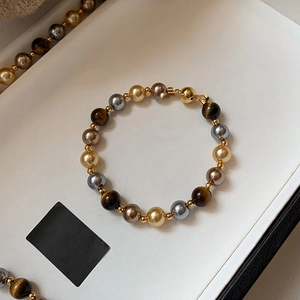 Vue détaillée de perles œil de tigre avec fermoir magnétique doré dans un coffret