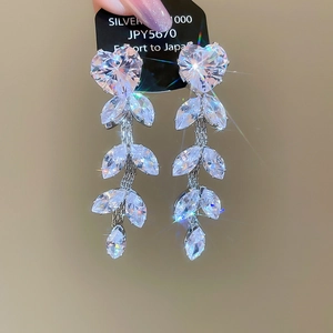 Detail of silver 1000 tassel earrings with heart-shaped cubic zirconia stones