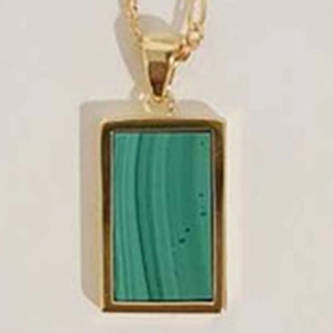 Macro shot of gold-plated rectangular green stone pendant with fine craft setting