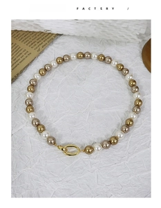 Detail of multi-color pearl necklace with champagne beads and gold oval metal clasp