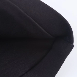 Détail macro du tissu noir de la mini robe licou avec texture textile de qualité