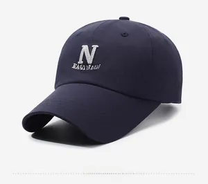 Detail view of navy blue baseball cap with white 3D letter N embroidery and curved brim