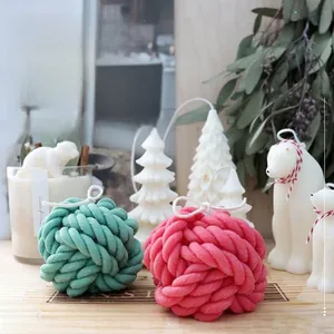 Detail of wool ball silicone candle mold with finished pink and cyan handmade samples