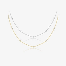 Detailed view of minimalist gold and silver curb chains with small circular metal beads