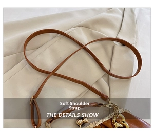 Detail of brown faux leather shoulder strap with gold metal clasp and vintage frame