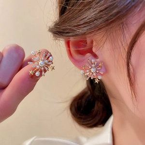 Elegant gold flower star earrings with pearls and crystals shown on a model