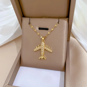 Close-up of a gold-plated titanium steel airplane necklace with sparkling crystals