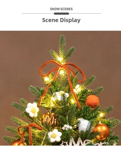 Detail of warm LED lights on a green mini Christmas tree with orange bows and ornaments
