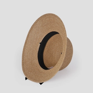 Detailed close-up of woven paper straw hat texture with inner black sweatband and label