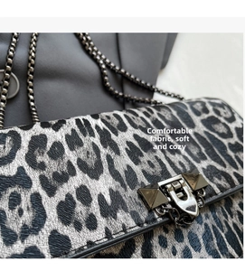 Detail der Leopardenmuster-Tasche mit dunkler Kette und Nietenschloss-Verschluss