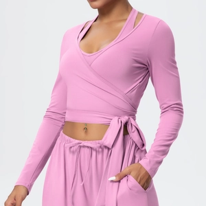 Detail of pink wrap tie-up yoga top showing stretch fabric texture and side knot