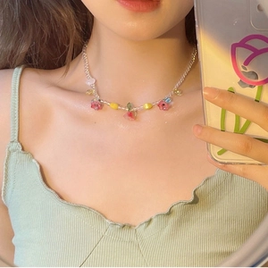 Détail de perles colorées en forme d'étoile et de fleur sur un collier d'été doux